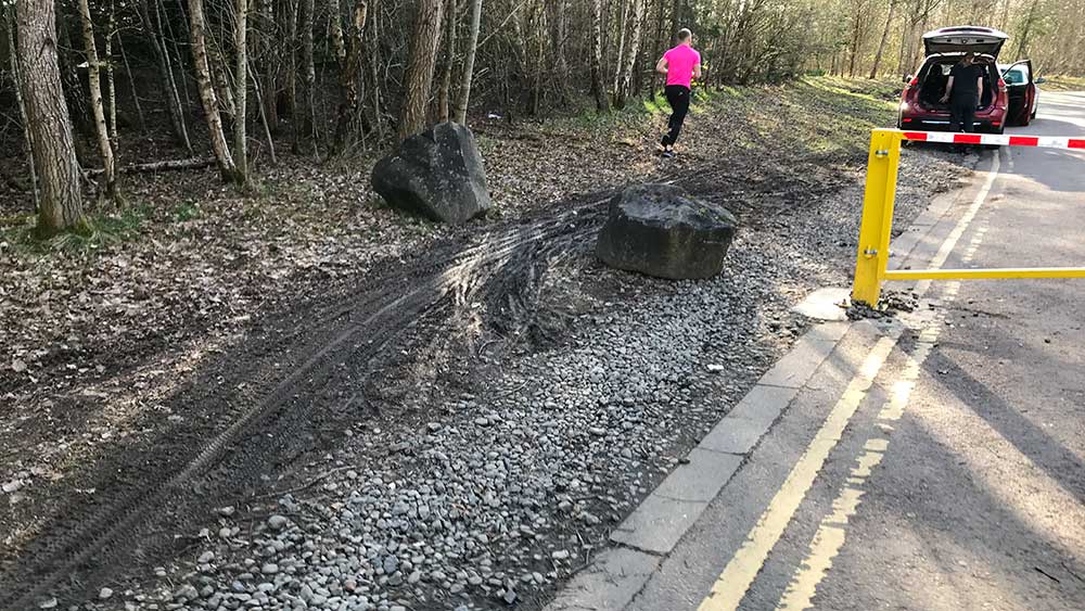 Strathclyde Park Spine Road at Bothwellhaugh roundabout showing bike tyre tracks in mud beside gate