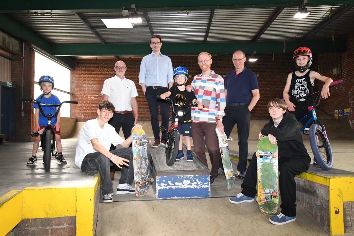 Politicians and council staff posing alongside kids with BMX bikes/skateboards